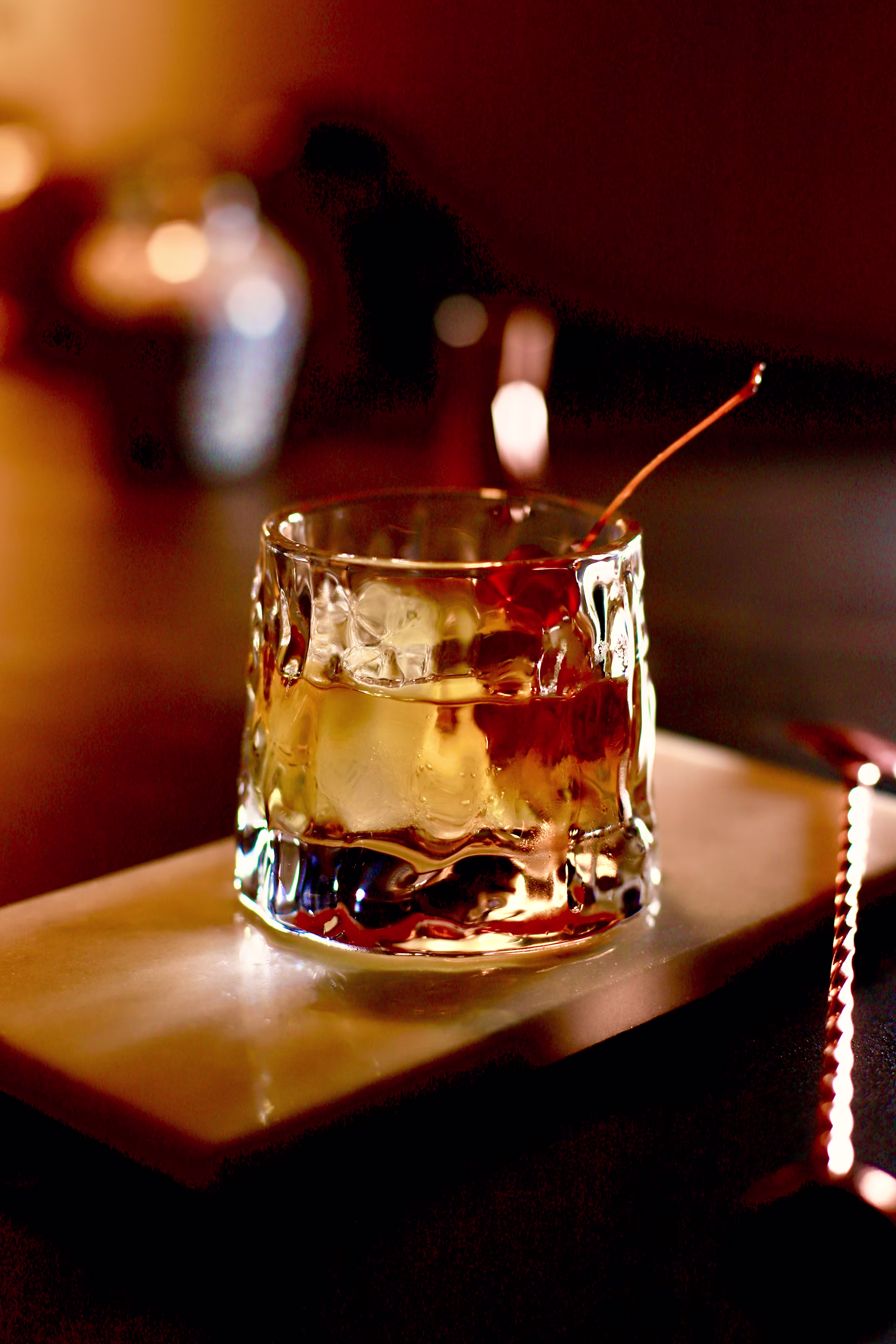 Smoked Cherry and Black Walnut Manhattan cocktail in a chilled coupe glass with smoked salt rim.